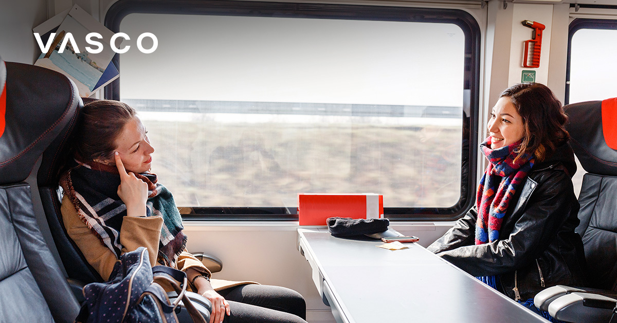 A young women smiling and sitting in the train.