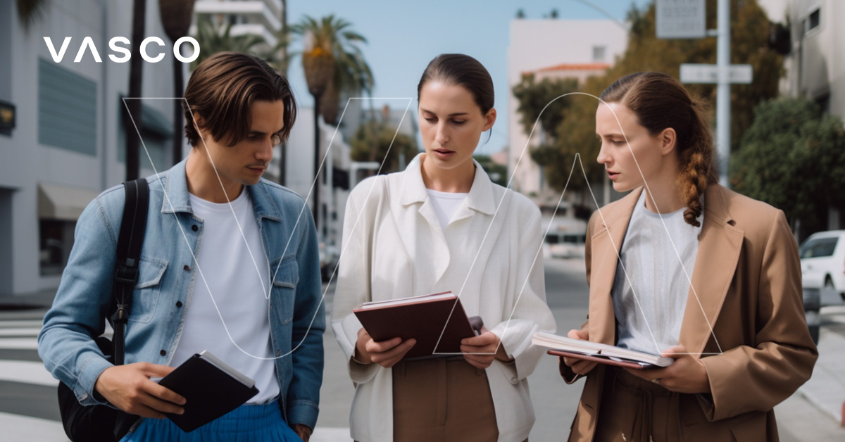 Three people looking at the notebook. Hollywood-like scenery in the background.