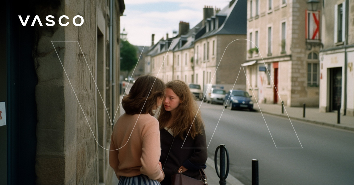 Two women talking to each other on a street. 