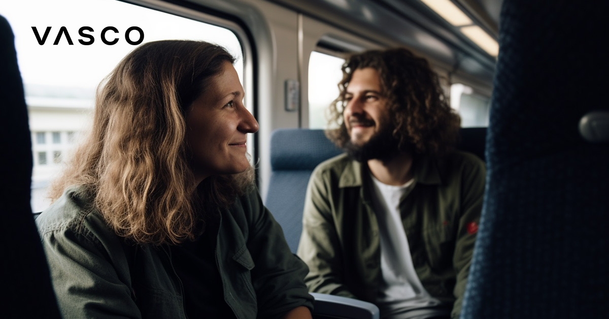 A smiling couple sitting on the train.