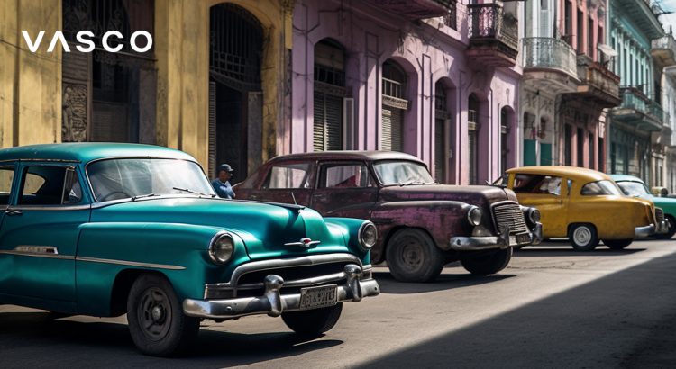Old cars driving on a street in Cuba.
