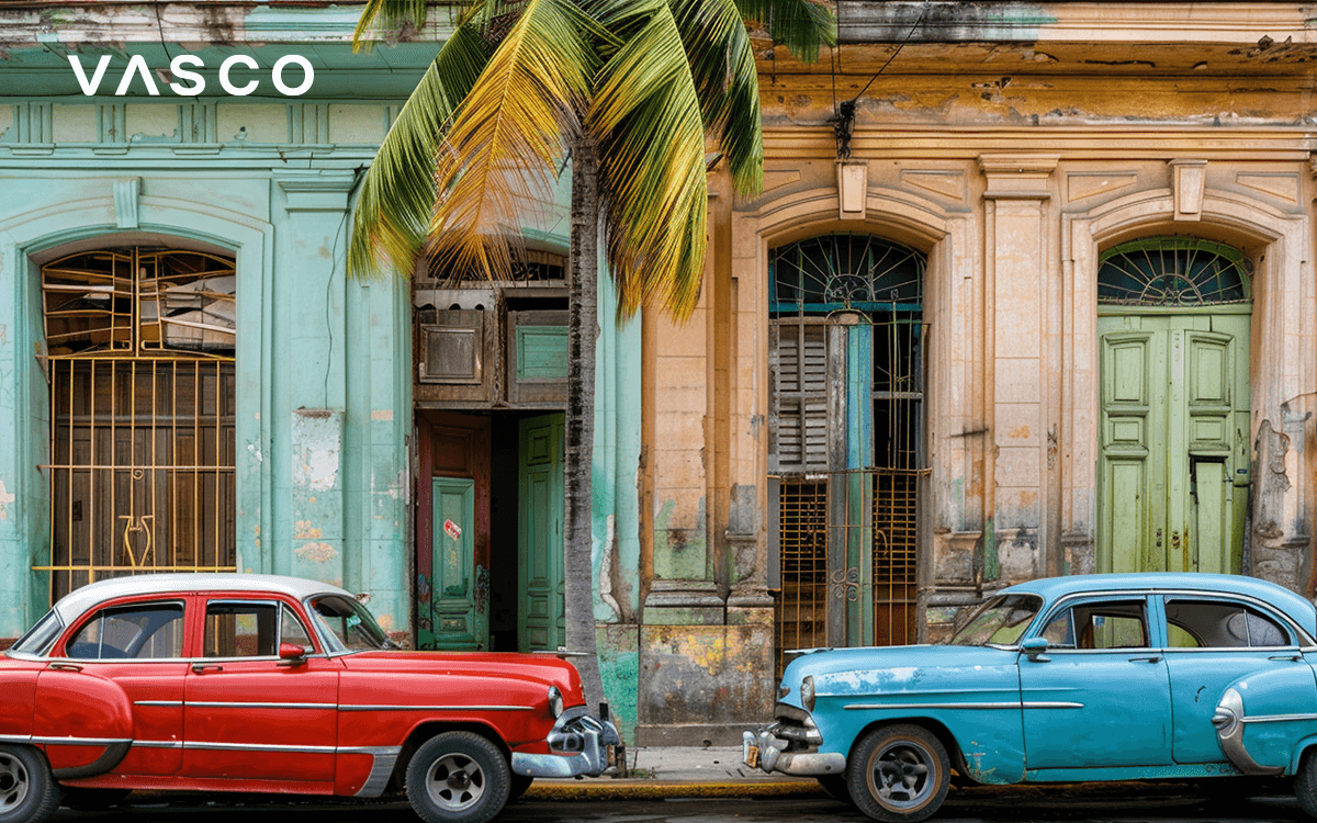 Street in Havana, Cuba with colorful cars parked near the buildings.