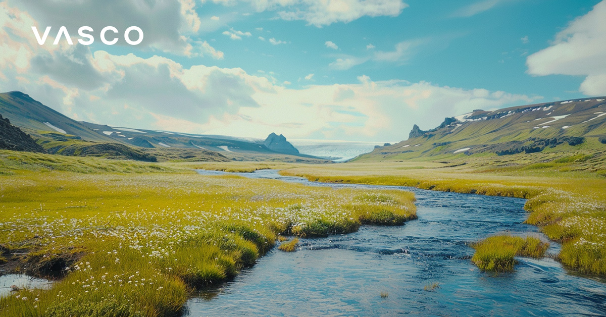 The picture shows an Icelandic river flowing through lush meadows. 