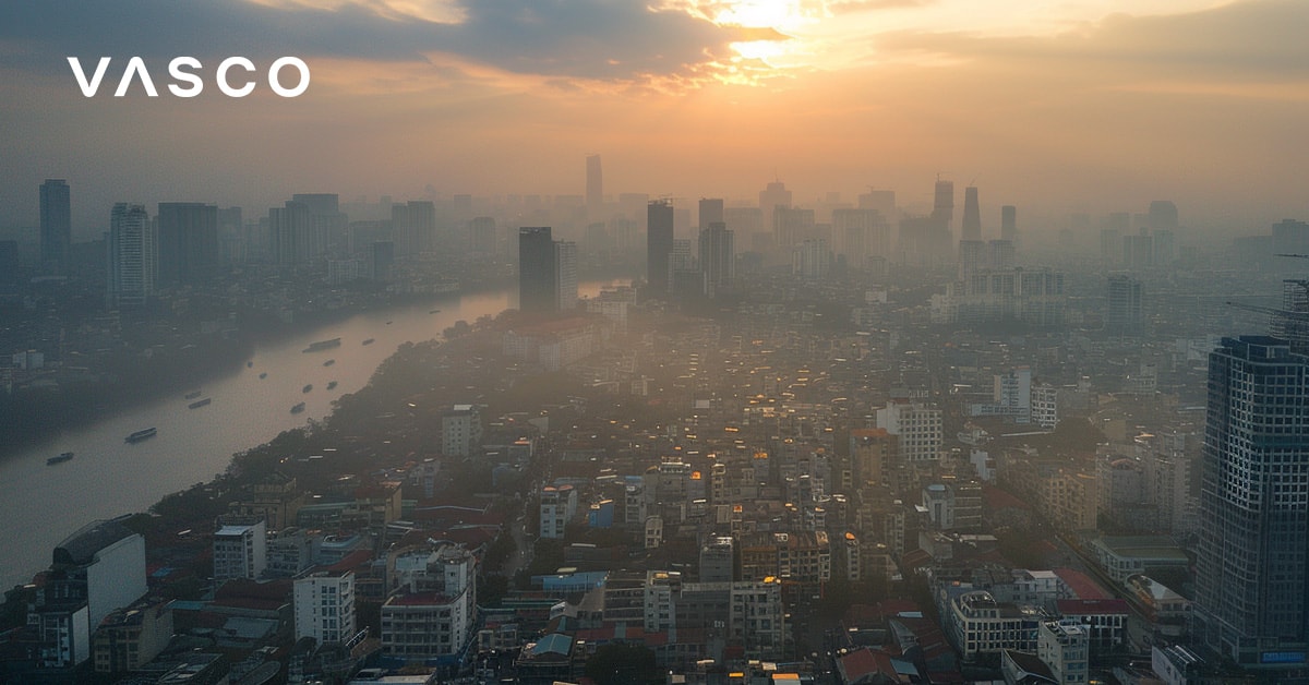 An aerial view of a cityscape at sunset with hazy skies, representing visiting Vietnam in October and what the weather is like.