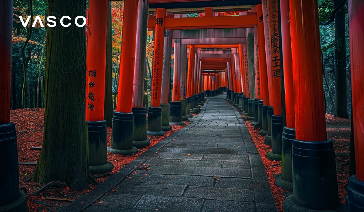 A path lined with vibrant red Torii gates in a serene forest setting.