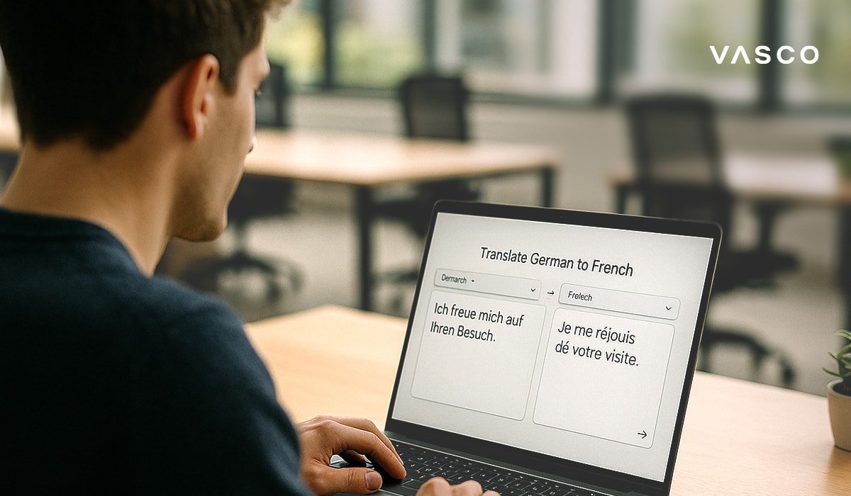 A man uses a laptop to translate a sentence from German to French in a modern workspace.