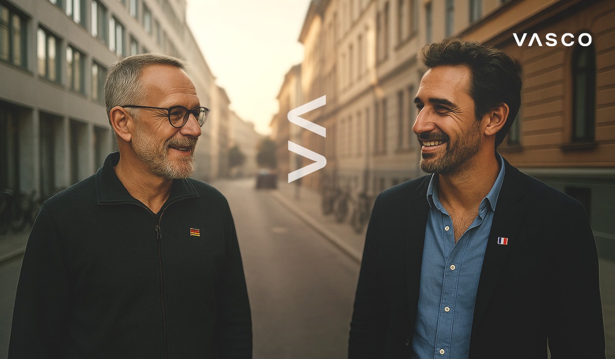 Two men walk through a city street, smiling and chatting casually.