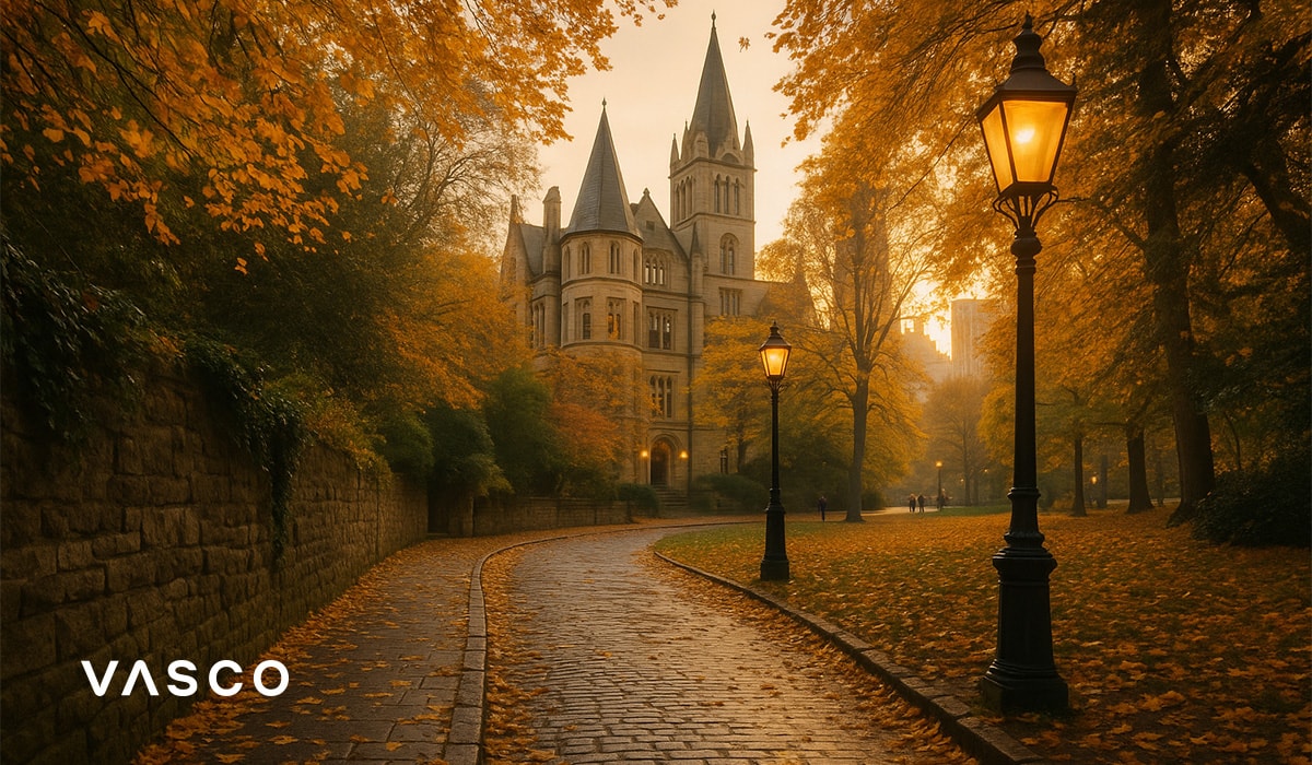 cobblestone path leading to a castle surrounded by golden autumn trees