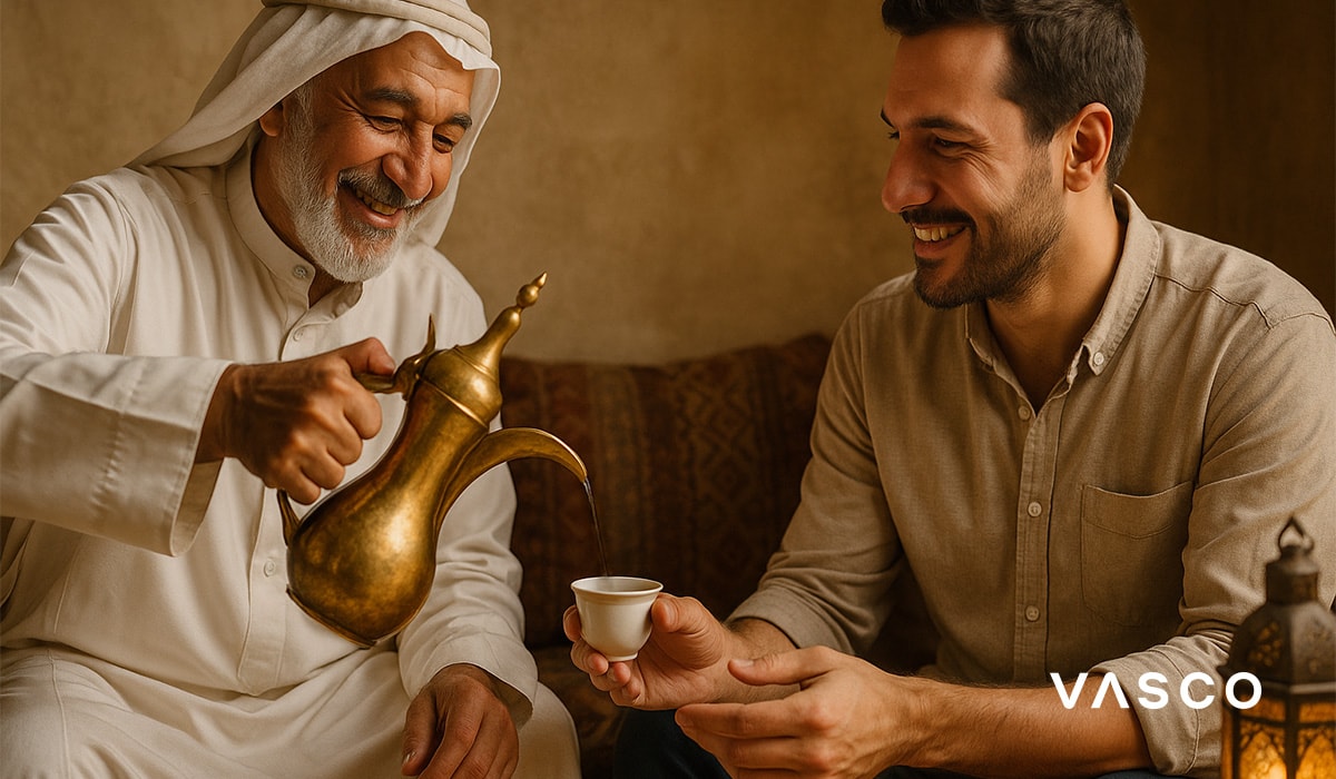 Two men sharing a traditional drink during a friendly meeting in an indoor setting
