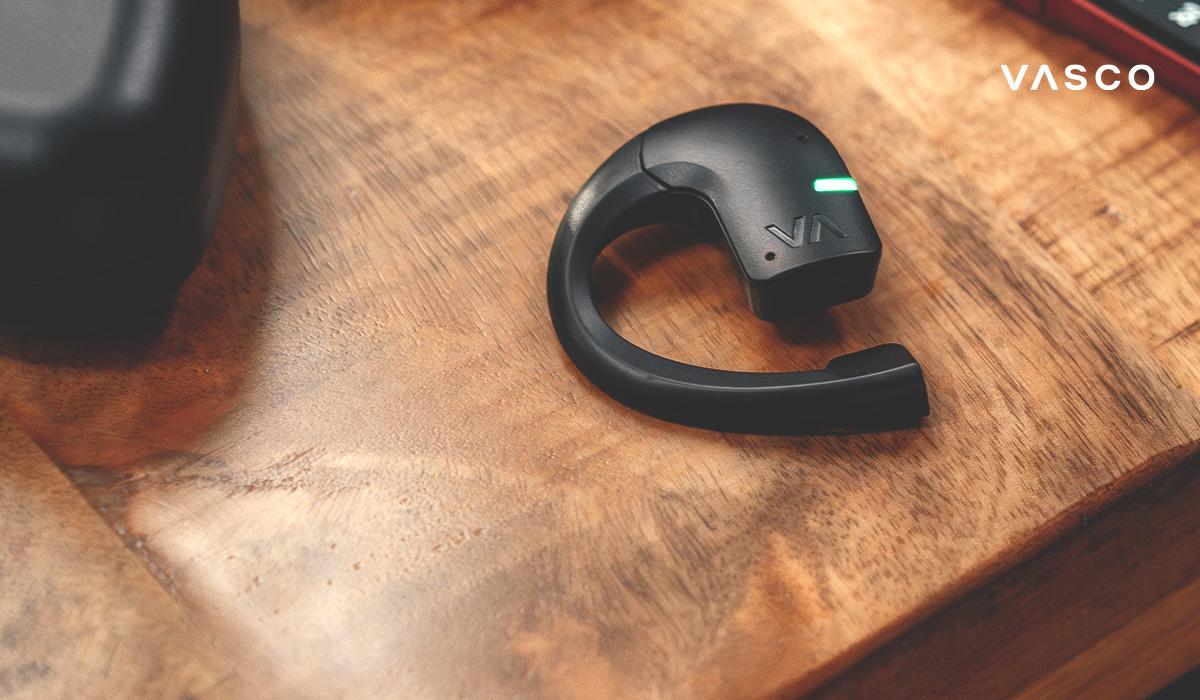vasco translator earbud close-up on wooden table with led indicator