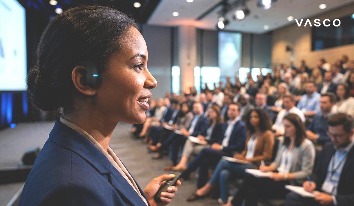 business woman using translator earbuds during international conference presentation