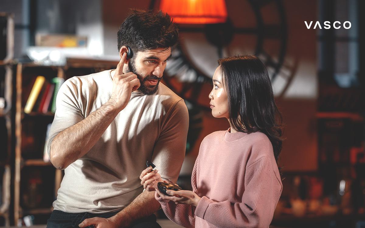 man and woman using ai translator earbuds for real-time multilingual conversation